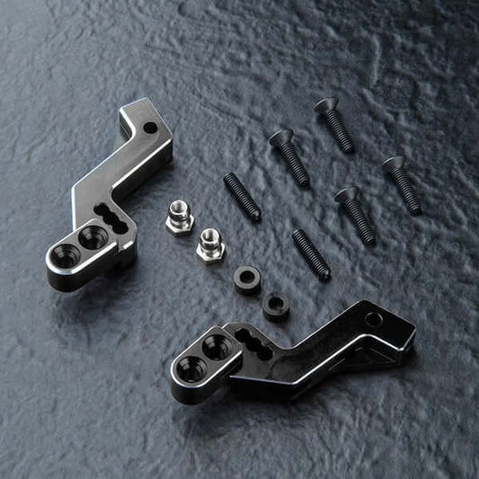 MST RMX 4 Damper Shock Tower components including aluminium parts and screws on a textured surface.