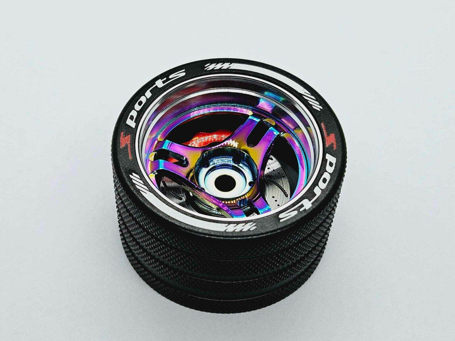 Close-up of the colourful RC transmitter steering wheel showing compatibility with major brands like SANWA, FUTABA, and FLYSKY