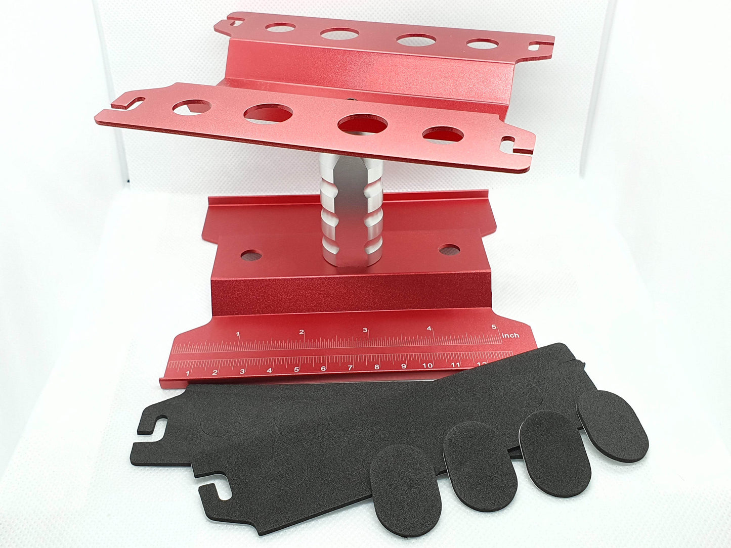 Close-up of the height-adjustable RC car stand, showcasing its sturdy construction and versatile use for 1/10 scale models - red
