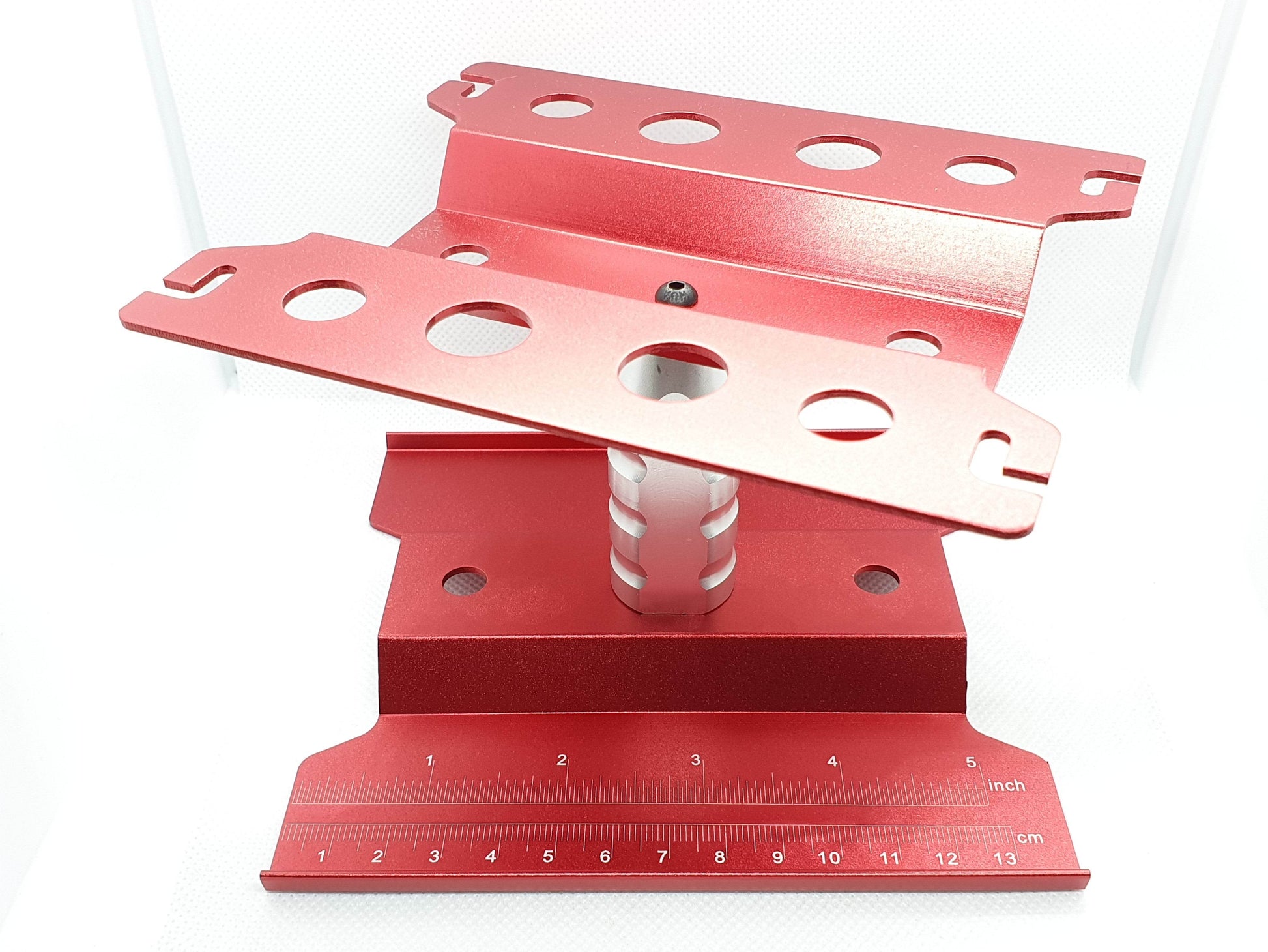 Close-up of the height-adjustable RC car stand, showcasing its sturdy construction and versatile use for 1/10 scale models - red